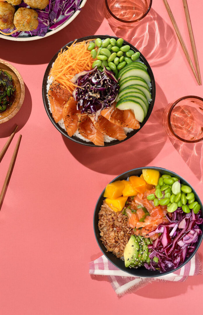 Menu poke Tastyrice avec bowls saumon, avocat, mangue, edamame et chou rouge, présenté sur fond rose. - Poké Bowl Paris - Poké Bowl Bordeaux