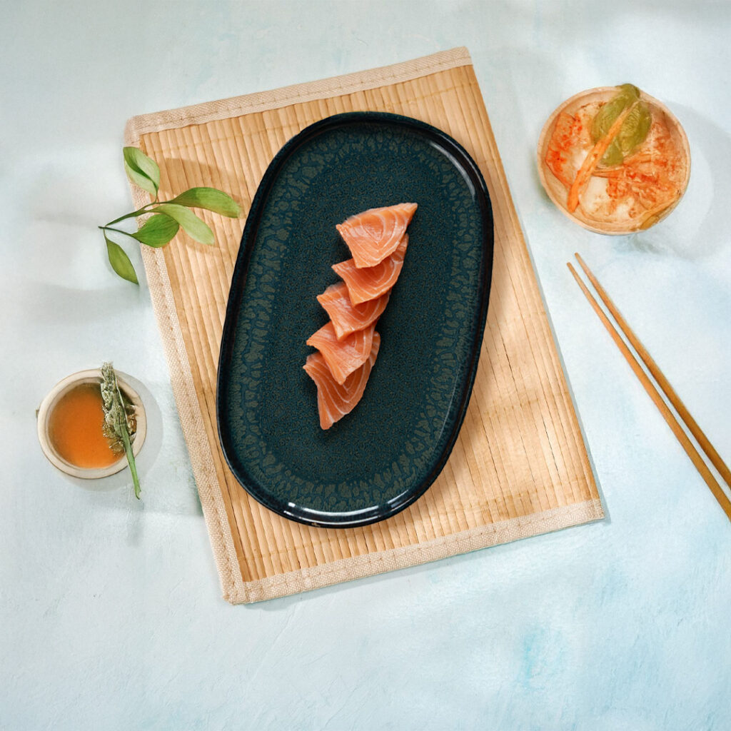 Tranches de sashimi de saumon frais Tastyrice servies sur assiette noire. - Sushi Paris - Sushi Bordeaux - Sashimis - Tatakis